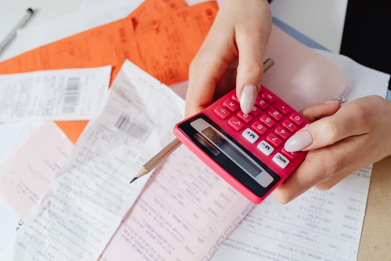 A calculator and receipts laid out on a desk while tallying costs