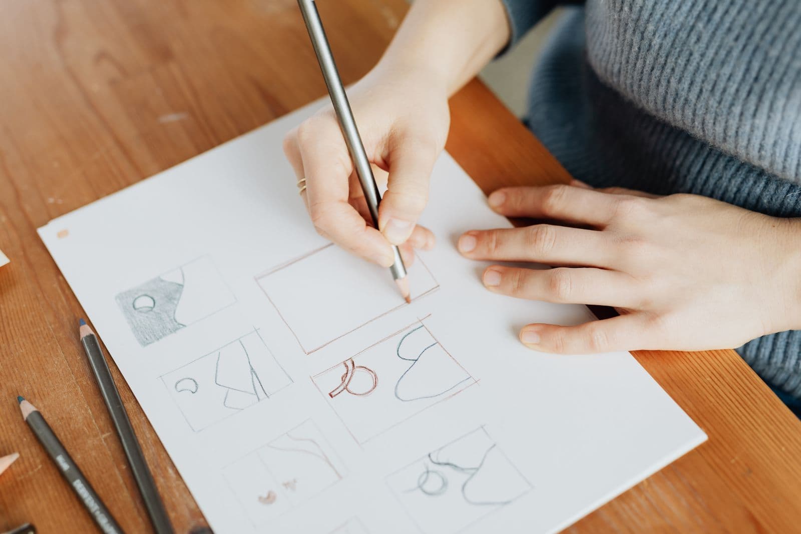 A designer's desk with logo sketches and design tools laid out